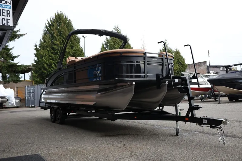 Slide: The Image of 2026 Harris Solstice 250 SL pontoon boat on trailer, parked outdoors. - 10