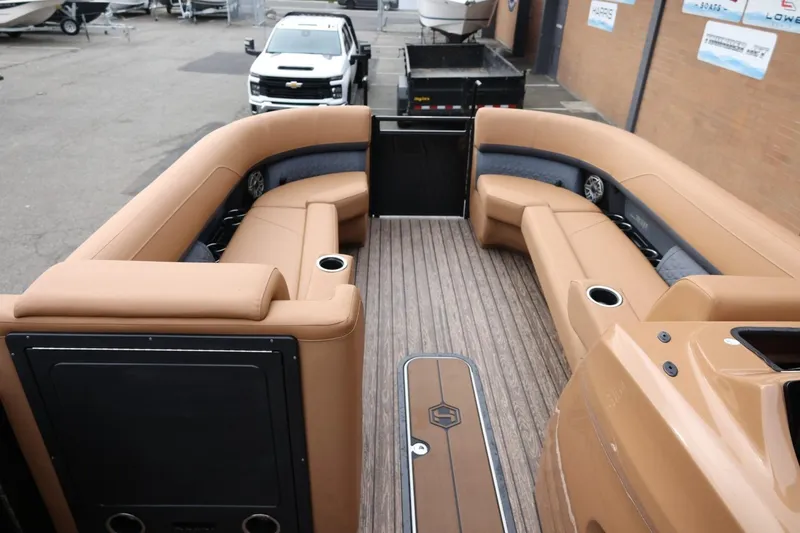 Slide: The Image of 2026 Harris Solstice 250 SL boat interior with tan seating and wood flooring. - 29