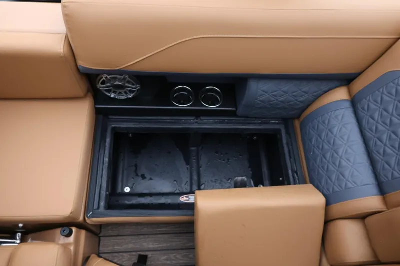 Slide: The Image of 2026 Harris Solstice 250 SL boat interior with tan and blue seating, storage compartment open. - 44
