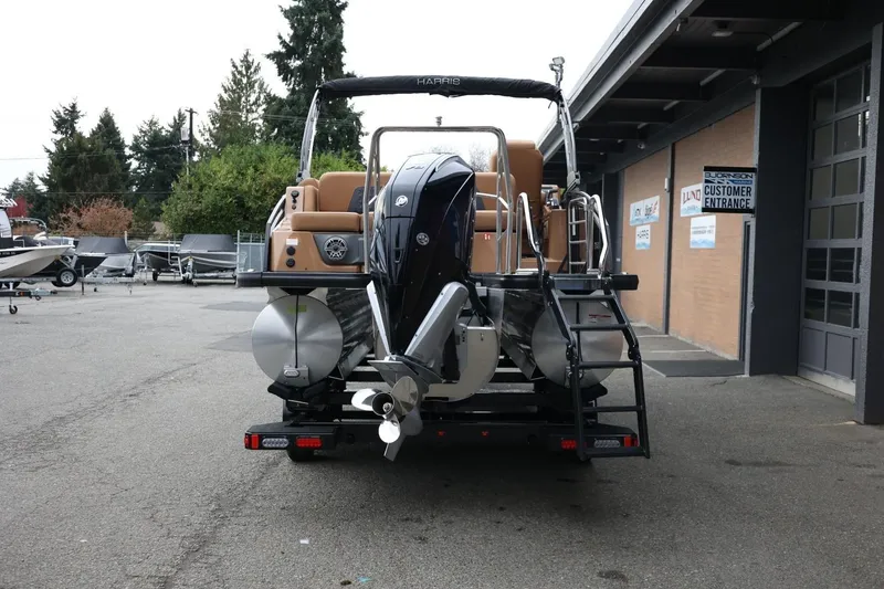Slide: The Image of 2026 Harris Solstice 250 SL pontoon boat rear view at dealership. - 5