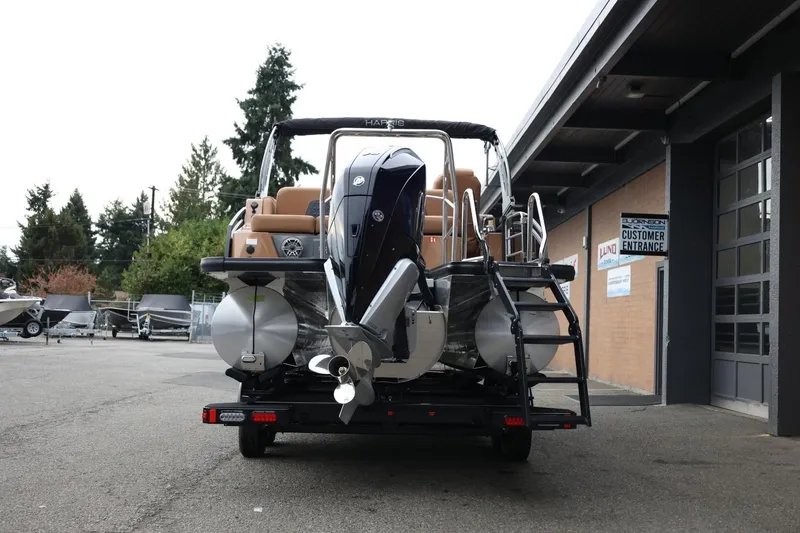 Slide: The Image of 2026 Harris Solstice 250 SL pontoon boat on trailer, parked outside dealership. - 6