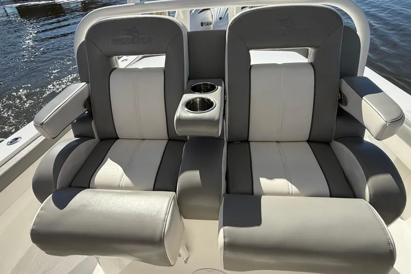 Slide: The Image of 2022 Regulator 34 boat seats with cup holders, featuring gray and white upholstery. - 18