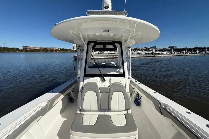 Slide: The Image of 2022 Regulator 34 boat on calm water, showcasing seating and helm station. - 21