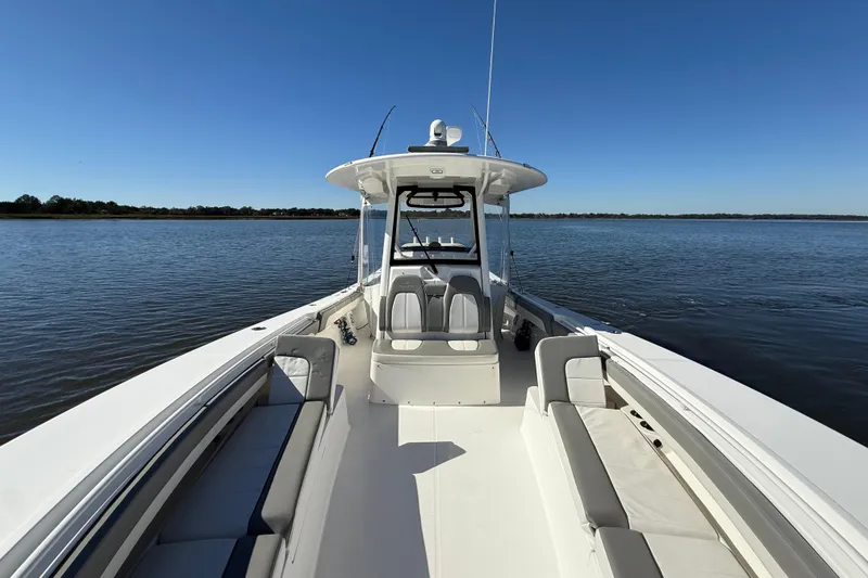 Slide: The Image of 2022 Regulator 34 boat on calm water, showcasing spacious deck and seating. - 24