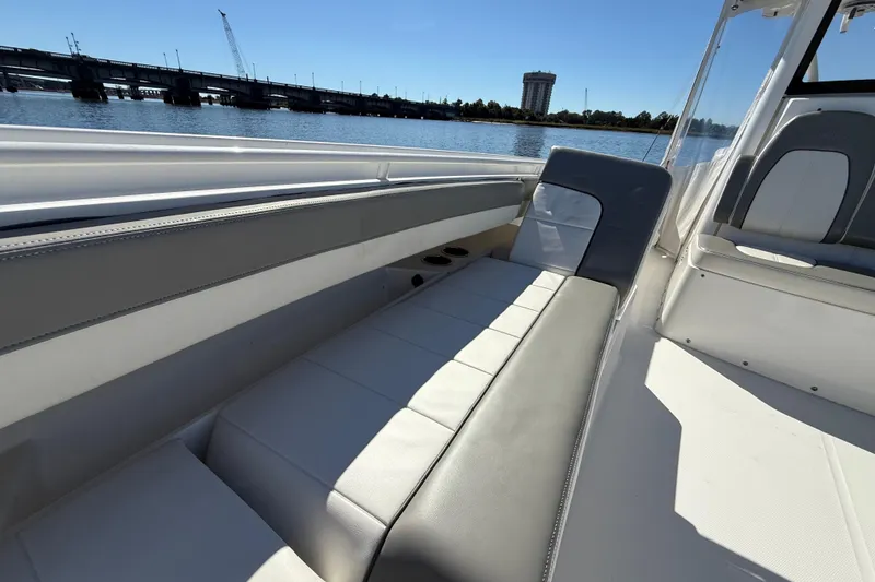 Slide: The Image of 2022 Regulator 34 boat interior with comfortable seating, overlooking a scenic waterfront. - 26