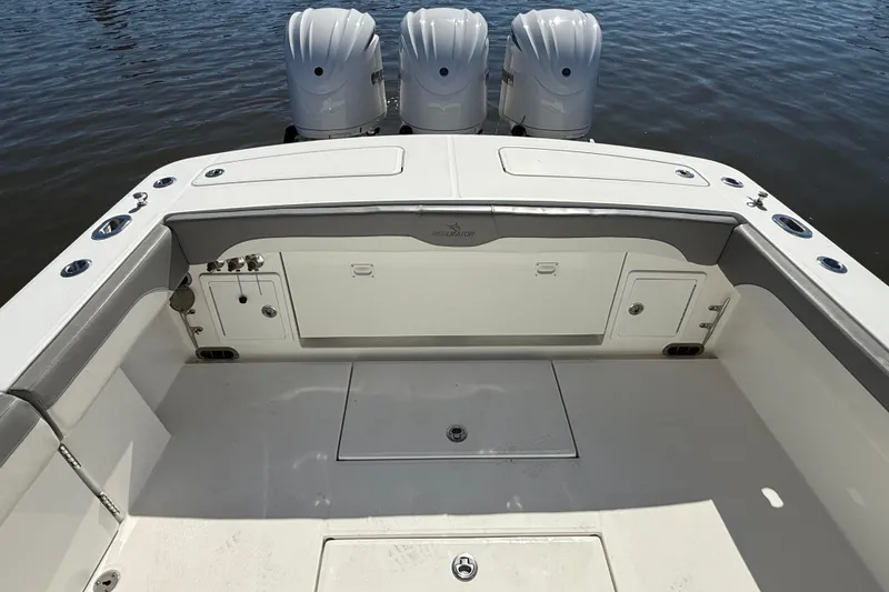 Slide: The Image of 2022 Regulator 34 boat deck with triple outboard motors on calm water. - 27