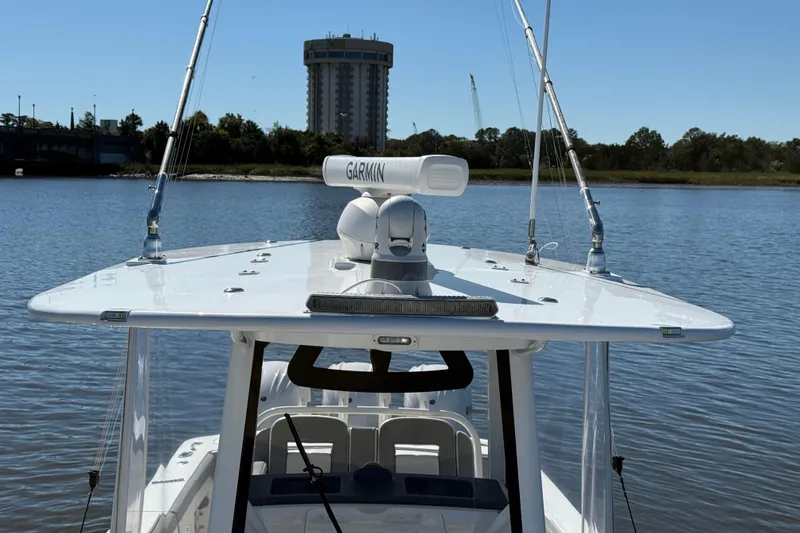Slide: The Image of 2022 Regulator 34 boat with Garmin radar on calm water, distant building in background. - 30