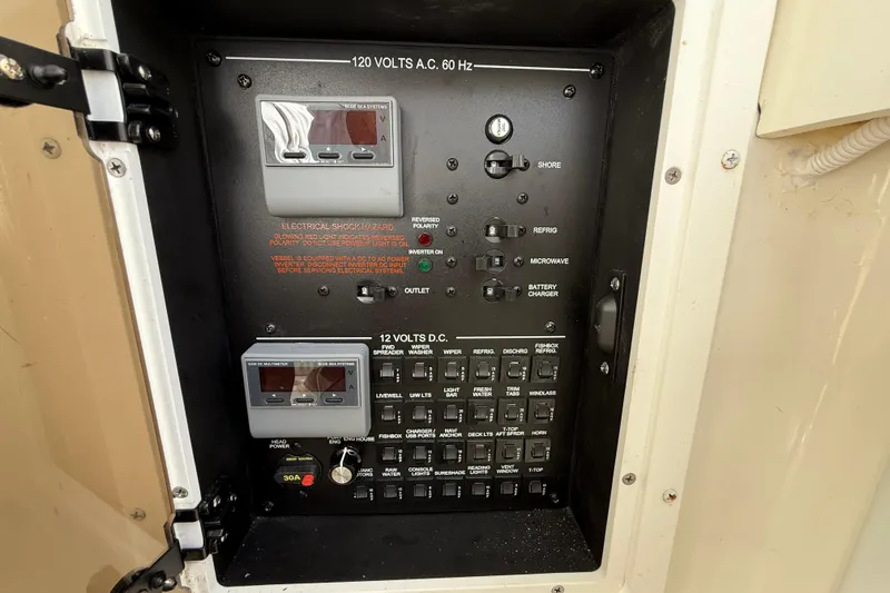 Slide: The Image of Electrical control panel on a 2022 Regulator 34 boat, featuring AC and DC switches. - 40