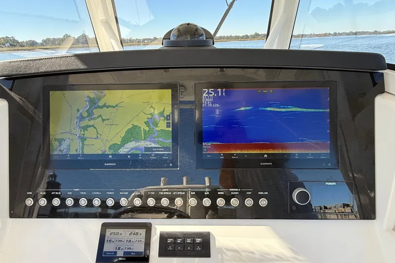 Slide: The Image of 2022 Regulator 34 boat dashboard with dual Garmin navigation screens and control panel. - 8