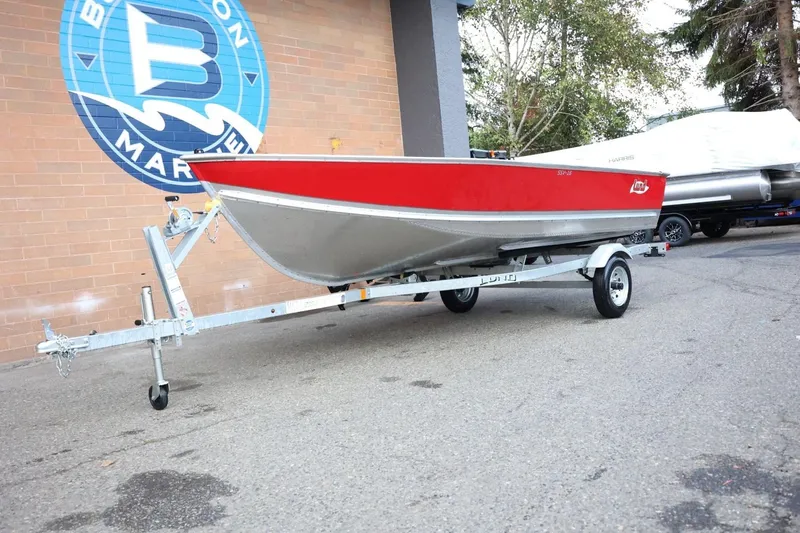 Slide: The Image of 2026 Lund SSV-16 Tiller boat on trailer, parked outside a marine store. - 15