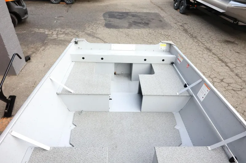 Slide: The Image of 2026 Lund SSV-16 Tiller boat interior with gray seating and storage compartments. - 18