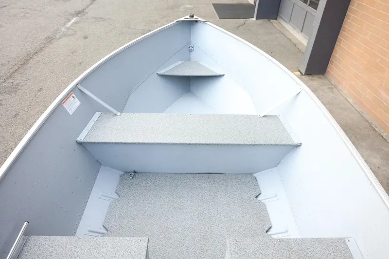 Slide: The Image of 2026 Lund SSV-16 Tiller boat interior with gray seating and flooring. - 19