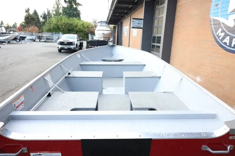 Slide: The Image of 2026 Lund SSV-16 Tiller boat displayed at a dealership, showcasing interior seating and design. - 24