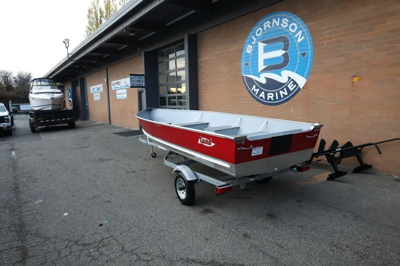Slide: The Image of 2026 Lund SSV-16 Tiller boat on trailer outside Bjornson Marine building. - 3