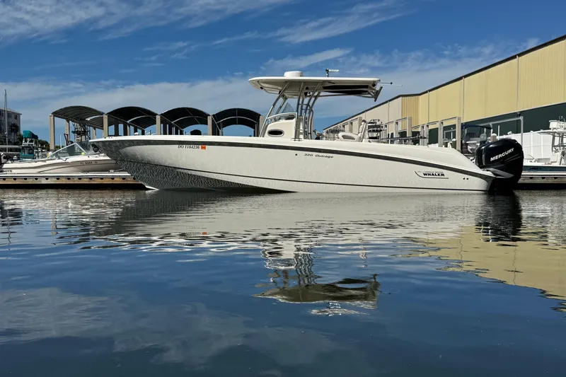 The Image of 2006 Boston Whaler 320 Outrage boat docked at marina, reflecting on calm water. - 0