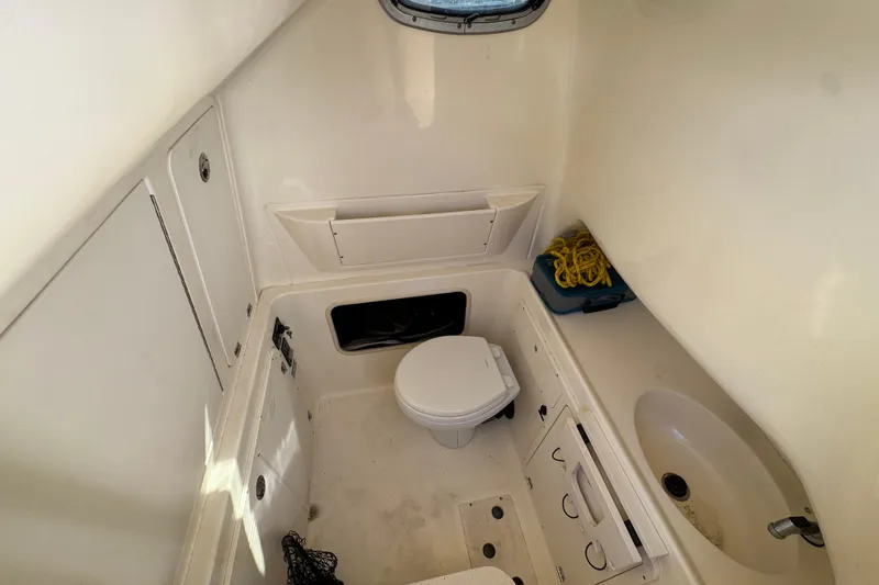 Slide: The Image of 2006 Boston Whaler 320 Outrage cabin interior with toilet and sink. - 22