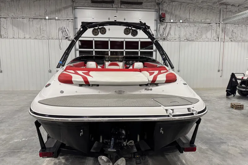 Slide: The Image of 2011 Four Winns 210 Horizon SS boat in a garage, rear view with red and white seating. - 5