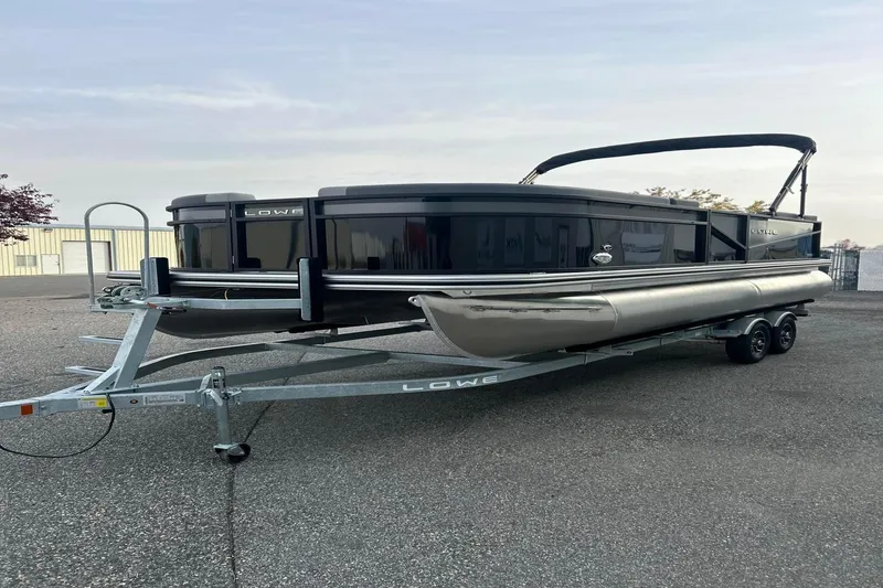 Slide: The Image of 2026 Lowe LS 210 WT pontoon boat on trailer, parked outdoors. - 4