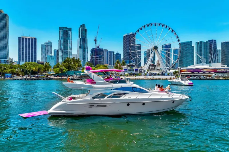 The Image of Azimut 50 Fly 2004 yacht cruising near city skyline and Ferris wheel on a sunny day. - 1