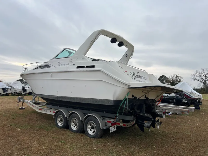 Slide: The Image of 1992 Sea Ray 300 boat on trailer, parked outdoors under cloudy sky. - 2