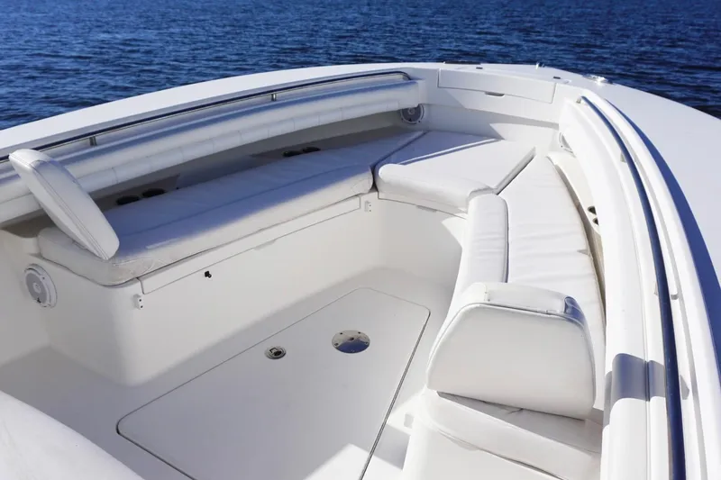 Slide: The Image of 2018 Regulator 28 boat interior with white cushioned seating, overlooking calm blue water. - 15
