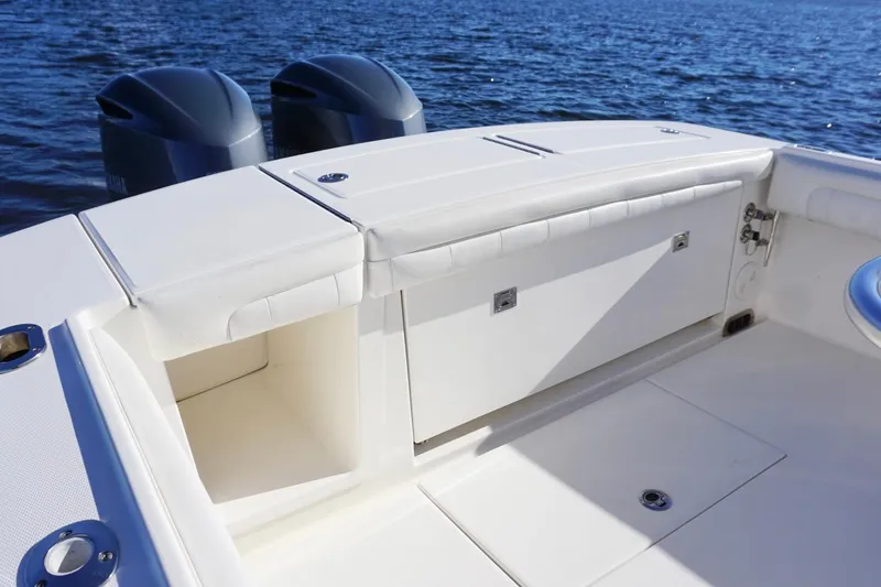 Slide: The Image of 2018 Regulator 28 boat interior with storage compartments and dual engines on the water. - 17