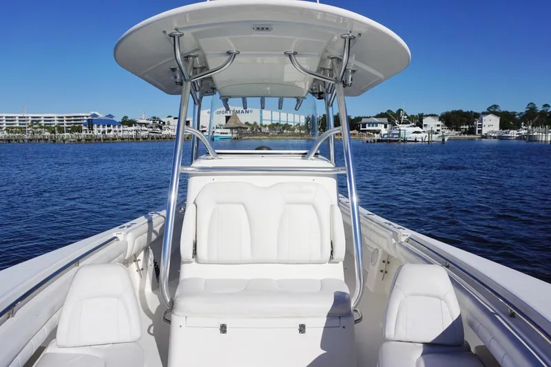 Slide: The Image of 2018 Regulator 28 boat on water, featuring sleek white seating and T-top. - 18