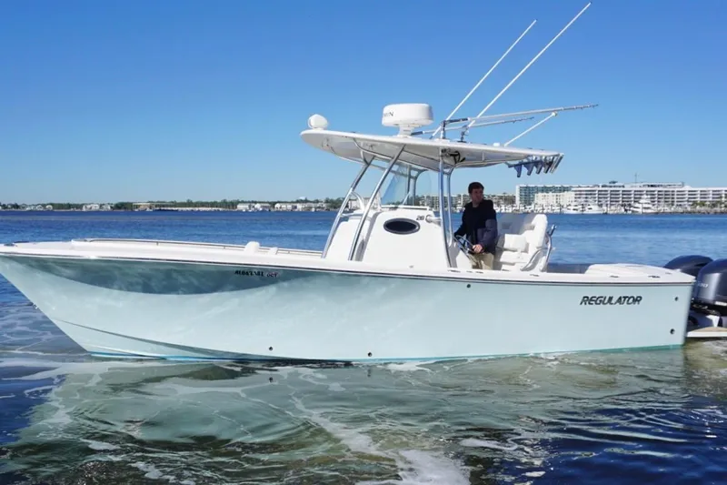 Slide: The Image of 2018 Regulator 28 boat cruising on calm waters under a clear blue sky. - 6