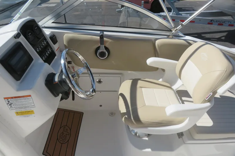 Slide: The Image of 2015 Sea Fox 226 Traveler boat cockpit with steering wheel and beige seating. - 18