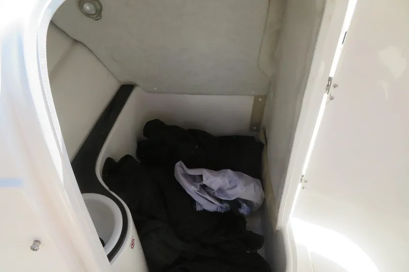Slide: The Image of Storage compartment inside 2015 Sea Fox 226 Traveler boat with clothing and a small bin. - 28