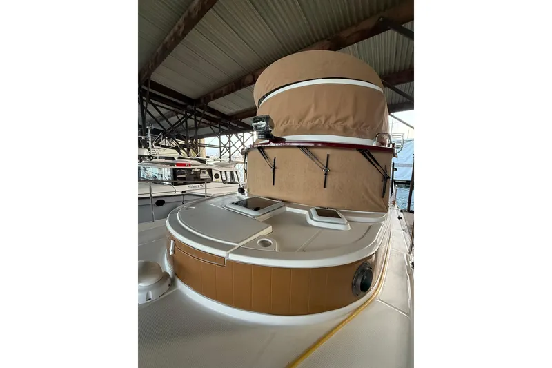 Slide: The Image of 2016 Ranger Tugs R-31 CB boat under a covered dock, showcasing its deck and structure. - 15