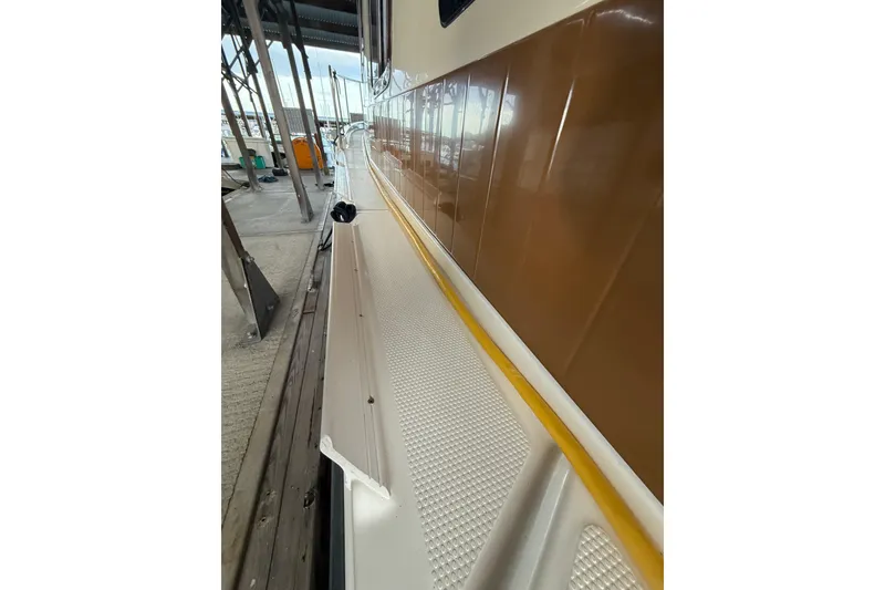 Slide: The Image of 2016 Ranger Tugs R-31 CB boat deck with brown exterior in marina. - 16