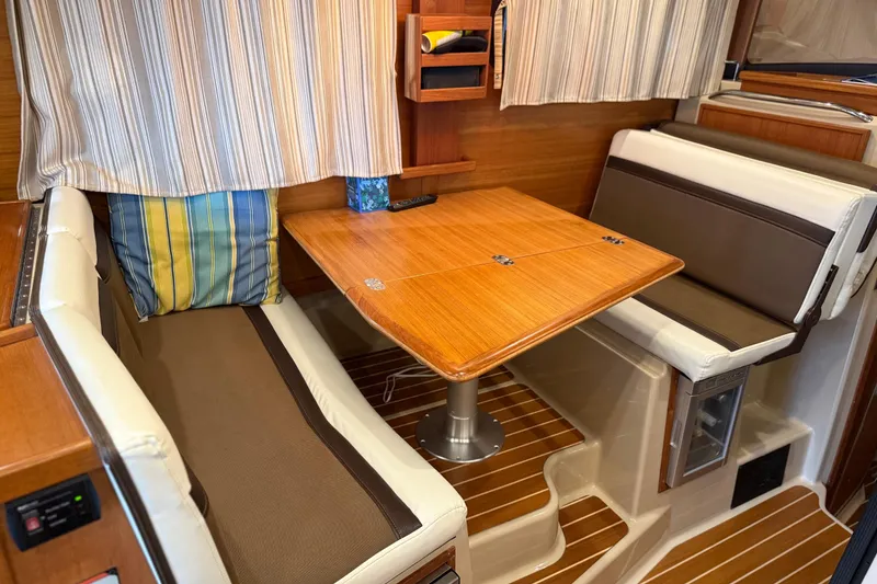 Slide: The Image of 2016 Ranger Tugs R-31 CB interior with cozy dining area and striped cushions. - 18