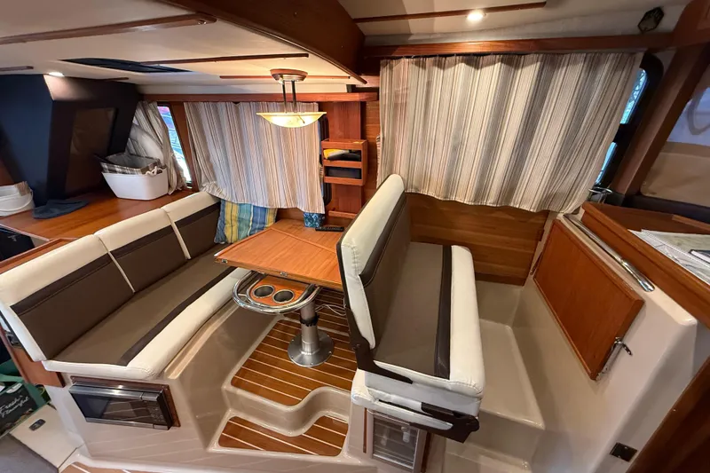 Slide: The Image of 2016 Ranger Tugs R-31 CB interior with cozy dining area and striped curtains. - 19