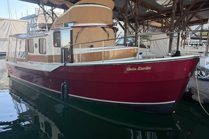 Slide: The Image of 2016 Ranger Tugs R-31 CB boat, red hull, docked with "Hello Darlin'" text. - 2