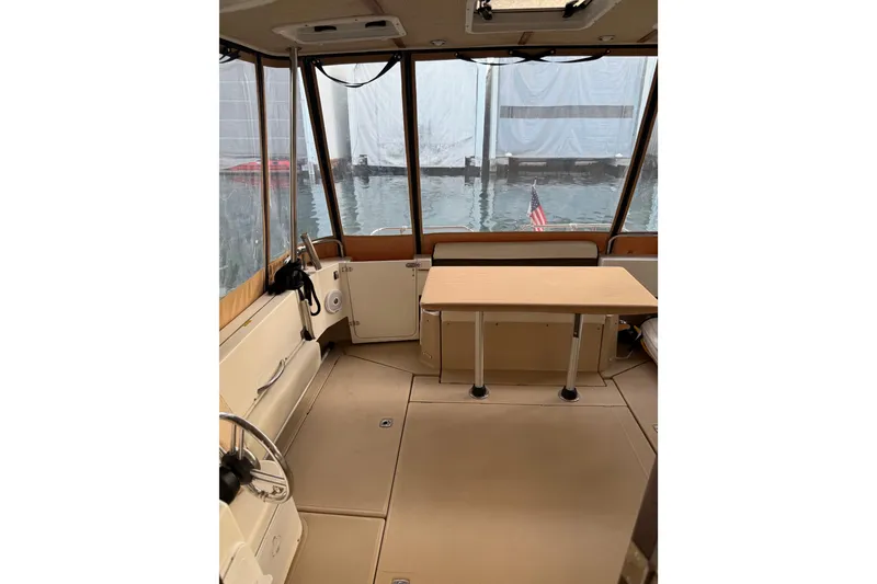 Slide: The Image of Interior of 2016 Ranger Tugs R-31 CB boat with table and helm, docked by water. - 25