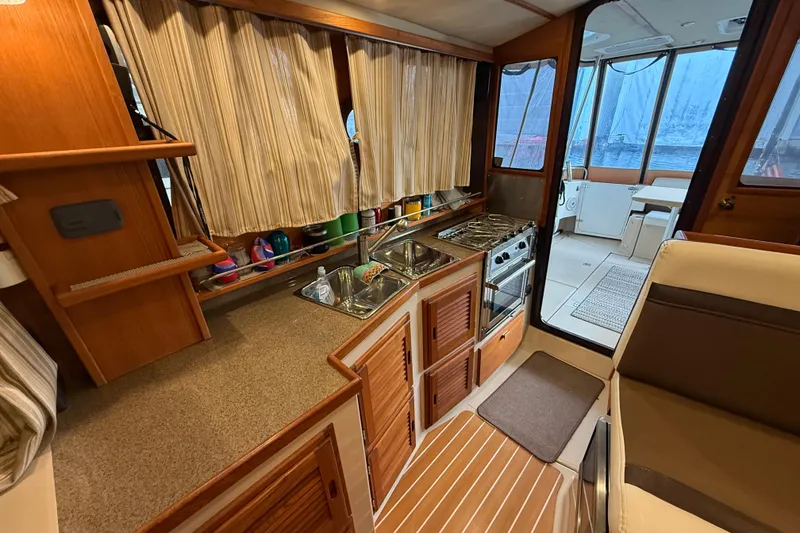 Slide: The Image of 2016 Ranger Tugs R-31 CB interior kitchen with stove, sink, and seating area. - 35