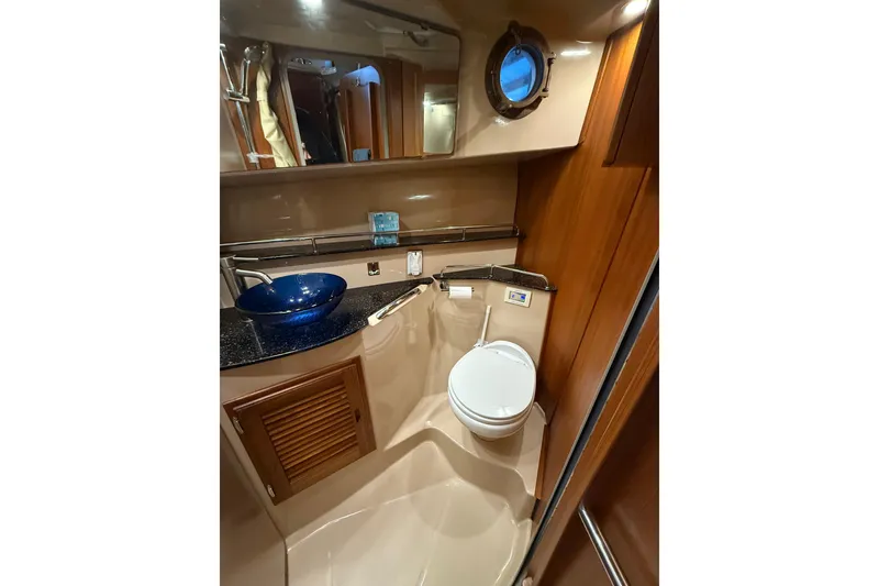 Slide: The Image of 2016 Ranger Tugs R-31 CB bathroom with blue sink, toilet, and porthole window. - 43