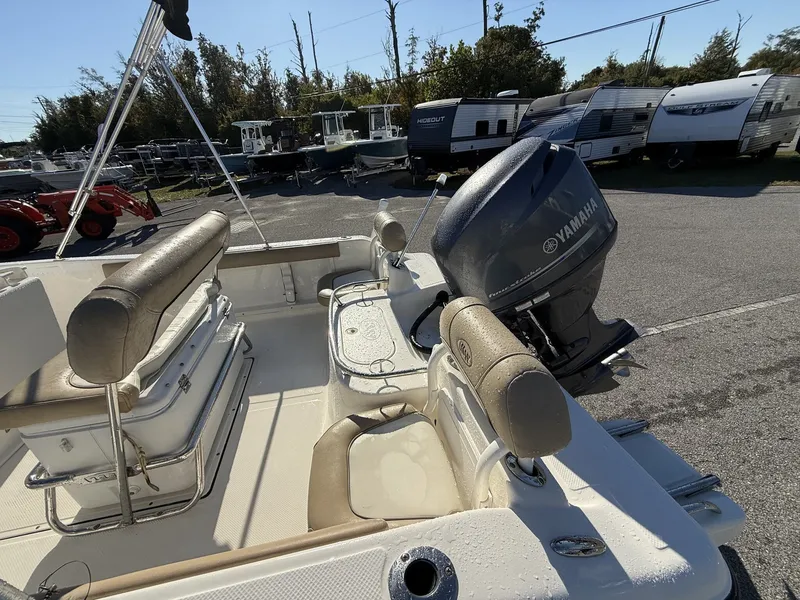 Slide: The Image of 2014 Key West 186br boat with Yamaha outboard motor, parked near trailers and trees. - 5