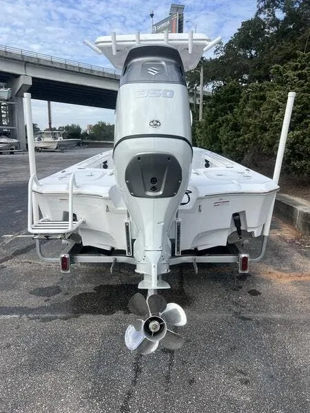 Slide: The Image of 2024 Blazer GTS 2550 BAY boat with powerful outboard motor, parked near a bridge. - 4