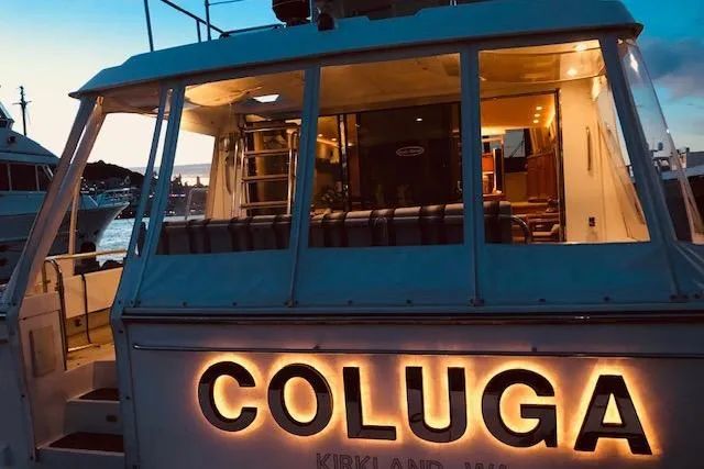 Slide: The Image of 1999 Pacific Mariner 65 Motoryacht "Coluga" docked at sunset, illuminated nameplate. - 15