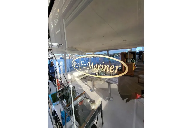 Slide: The Image of 1999 Pacific Mariner 65 Motoryacht interior with logo reflection on glass. - 16