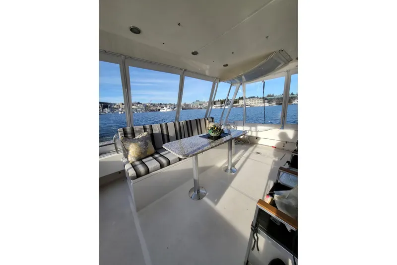 Slide: The Image of 1999 Pacific Mariner 65 Motoryacht interior with striped seating and waterfront view. - 17
