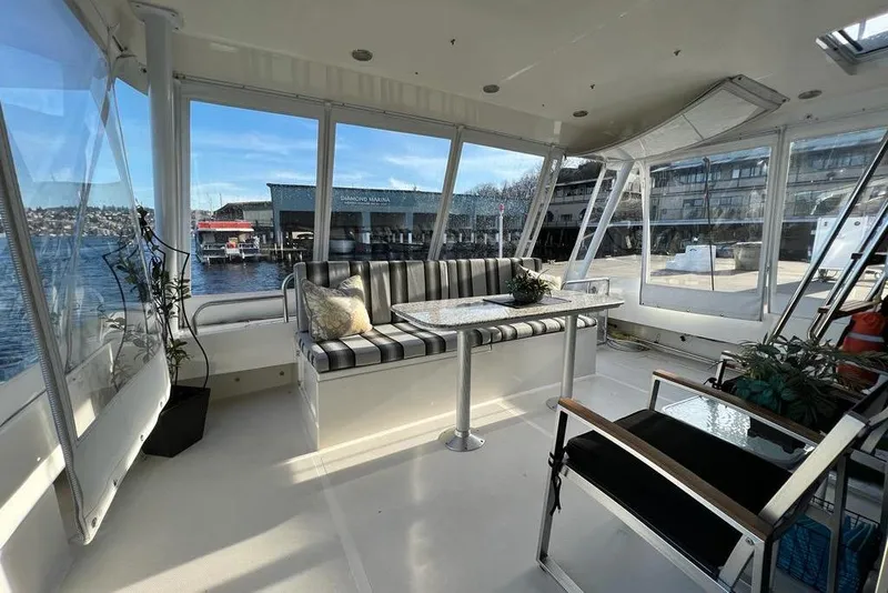 Slide: The Image of 1999 Pacific Mariner 65 Motoryacht interior with striped seating and marina view. - 20