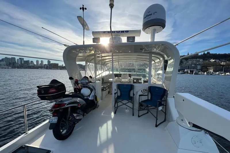 Slide: The Image of 1999 Pacific Mariner 65 Motoryacht with motorcycle on deck, city skyline in background. - 21