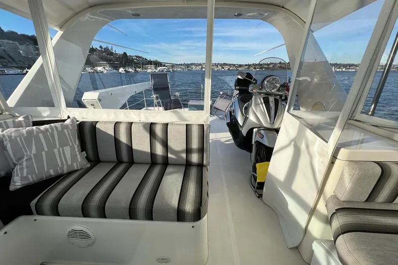 Slide: The Image of 1999 Pacific Mariner 65 Motoryacht interior with striped seating and a scooter on deck. - 23