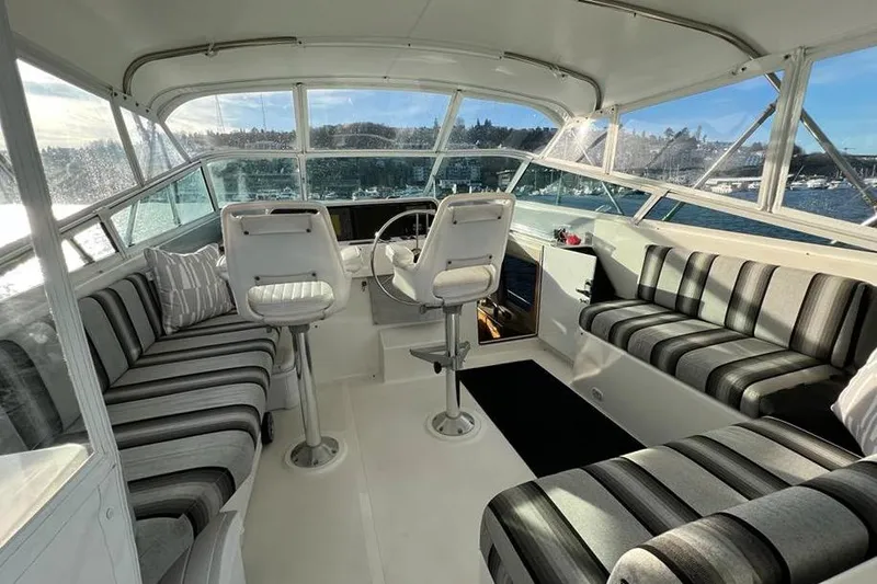 Slide: The Image of 1999 Pacific Mariner 65 Motoryacht interior with striped seating and panoramic windows. - 24