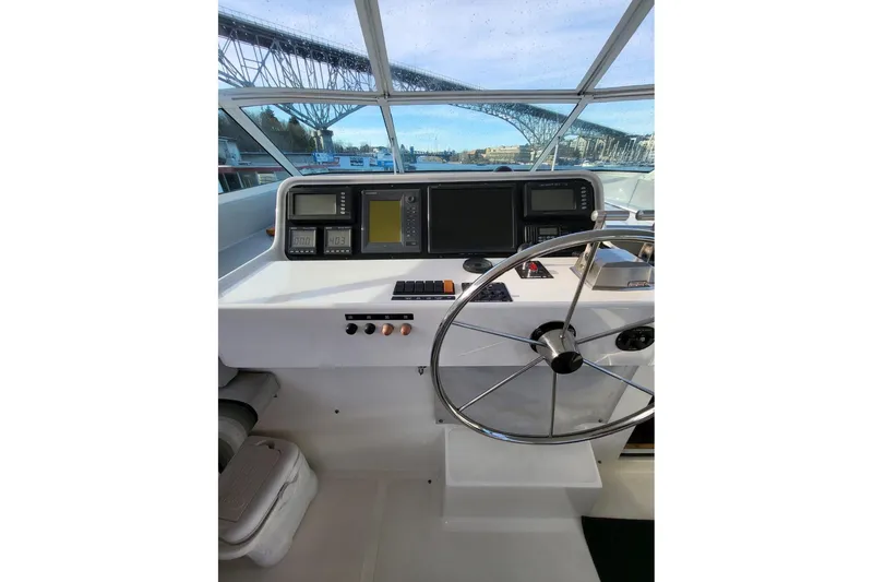 Slide: The Image of 1999 Pacific Mariner 65 Motoryacht helm with navigation instruments and steering wheel. - 26