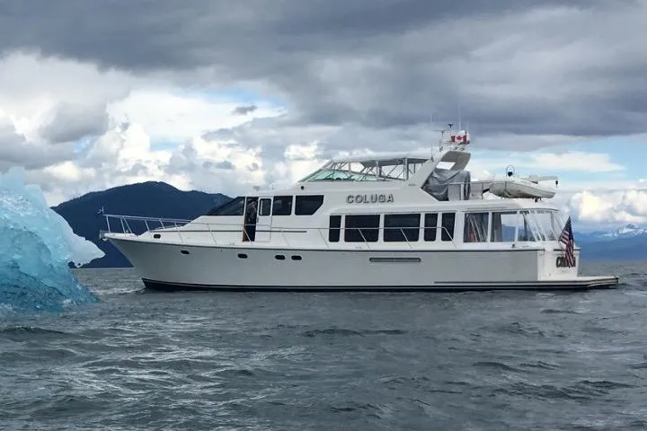 Slide: The Image of 1999 Pacific Mariner 65 Motoryacht cruising near an iceberg under cloudy skies. - 3