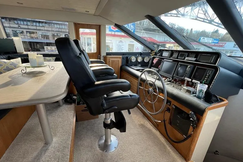 Slide: The Image of 1999 Pacific Mariner 65 Motoryacht helm with leather seats, steering wheel, and navigation instruments. - 41